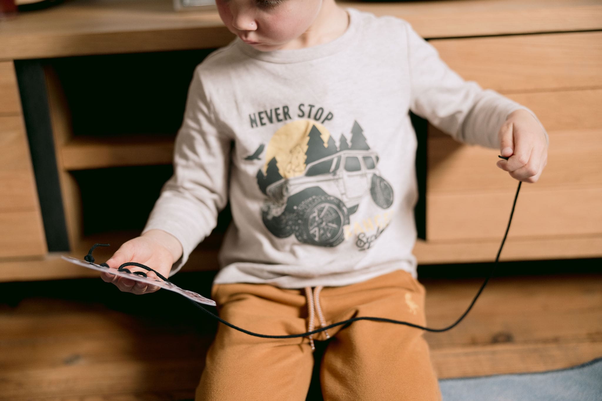 Jeune enfant qui verse de l’eau d’un petit pichet à l’autre sur un plateau, activité Montessori de vie pratique